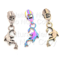Load image into Gallery viewer, A set of three zipper pulls with a fantasy-themed seamonster design. Shown in antique nickel, rainbow and bronze.