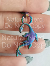 Load image into Gallery viewer, A zipper pull with a fantasy-themed seamonster design. Shown in matte rainbow.