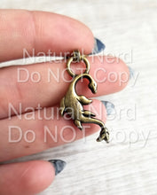 Load image into Gallery viewer, A zipper pull with a fantasy-themed seamonster design. Shown in bronze.