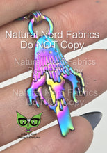 Load image into Gallery viewer, Rainbow metal zipper pull shaped like a dripping inky cap mushroom. The pull has a detailed design with a textured surface.