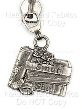Load image into Gallery viewer, Silver-toned zipper pull featuring a stack of books with the words "Smut" and "Slut" on the spines. The design includes a rose and a book with a chili pepper. A metal ring connects the pull to the zipper.
