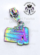 Load image into Gallery viewer, Iridescent zipper pull featuring a stack of books with the words "Smut" and "Slut" on the spines. The design includes a rose and a book with a chili pepper. A metal ring connects the pull to the zipper.