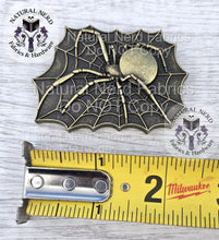 Load image into Gallery viewer, A bronze-colored spider web and spider embellishment. The spider is centered on the web, with a round body and long legs. The web is rectangular with a scalloped edge. The embellishment measures approximately 2 inches in length.