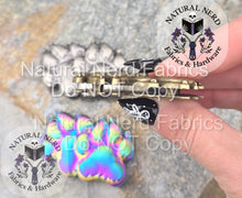 Load image into Gallery viewer, hand holding the paw print magnetic snap to the side to how it's raised quality and thickness