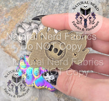 Load image into Gallery viewer, Hand holding the bronze paw print magnetic snap, shwing the back side features the snap installation space and four plate securing screws