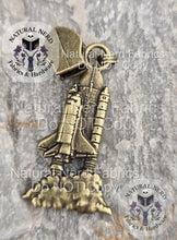 Load image into Gallery viewer, An bronze detailed zipper pull designed to look like a launching space shuttle.