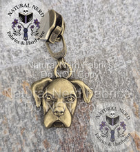 Load image into Gallery viewer, Bronze dog head zipper pull on a textured surface with 'Natural Nerd' branding. The dog breed is a boxer.