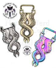 Load image into Gallery viewer, Three octopus-themed purse strap anchors with a twisting tentacle design on a white background, showing antique bronze, silver, and iridescent holographic finishes. The silver is flipped to the back to show that the anchors are secured with three screws. Watermarks for 'Natural Nerd Fabrics & Hardware' are visible.