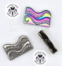 Load image into Gallery viewer, Two wavy octopus tentacle-shaped metal strap ends shown on a white background, one in silver-toned metal and one in rainbow-toned metal. A third matching piece is shown from the top.