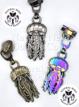 Load image into Gallery viewer, a set of three jelly-fish shaped zipper pulls shown in bronze, antique nickel, and matte rainbow finishes