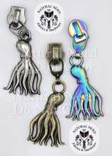 Load image into Gallery viewer, Three octopus-shaped zipper pull charms displayed side by side on a light gray background. The left charm is antique silver, the middle charm is antique bronze, and the right charm is iridescent rainbow-colored.