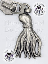 Load image into Gallery viewer, A silver-toned metal octopus zipper pull with detailed tentacles and suction cup patterns, shown on a white background with 'Natural Nerd Fabrics & Hardware' watermarks.