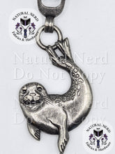Load image into Gallery viewer, A silver-toned metal seal zipper pull, shown on a white background with repeated 'Natural Nerd Fabrics & Hardware' watermarks.