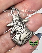 Load image into Gallery viewer, Antique silver metal zipper pull featuring a plague doctor with a long beak, wearing a hat and goggles. 

