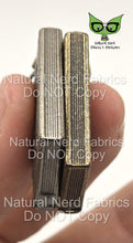 Load image into Gallery viewer, Two miniature books, one silver and one gold, with detailed texture to mimic pages. The books are held in a hand.
