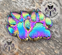 Load image into Gallery viewer, matte rainbow paw print magnetic snap design on a textured surface with 'Natural Nerd' branding.
