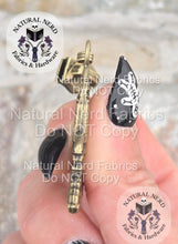 Load image into Gallery viewer, Hand holding a bronze space shuttle zipper pull to the side to show thickness.
