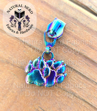 Load image into Gallery viewer, A rainbow detailed zipper pull designed to look like a pair of canine paw prints. 
