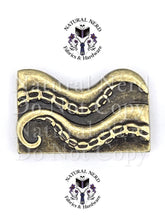 Load image into Gallery viewer, A bronze metal octopus strap end with detailed suction cups, shown on a white background with 'Natural Nerd Fabrics &amp; Hardware' watermarks.
