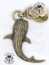 Load image into Gallery viewer, An antiqued bronze metal whale shark zipper pull with textured detailing. The image features 'Natural Nerd Fabrics &amp; Hardware' watermarks on a white background.
