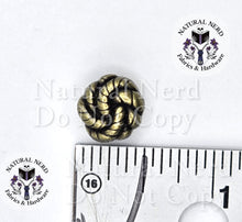 Load image into Gallery viewer, A small metallic knot-shaped Chicago screw with an antique bronze finish, shown next to a ruler for scale on a white background with 'Natural Nerd Fabrics &amp; Hardware' watermarks.
