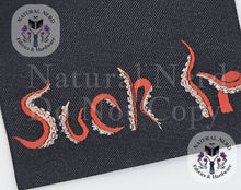 Load image into Gallery viewer, A close up of a black fabric tag with the phrase 'Suck It' embroidered in red and white tentacle shaped font, overlaid with watermark text from Natural Nerd Fabrics &amp; Hardware.
