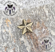 Load image into Gallery viewer, Bronze star-shaped Chicago screw on a textured surface with 'Natural Nerd' branding. 
